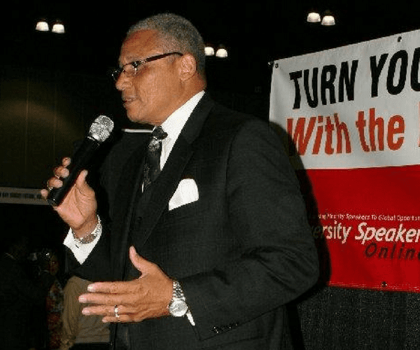 A man in a suit and tie holding a microphone.