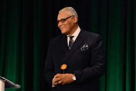 A man in a suit holding a flower.